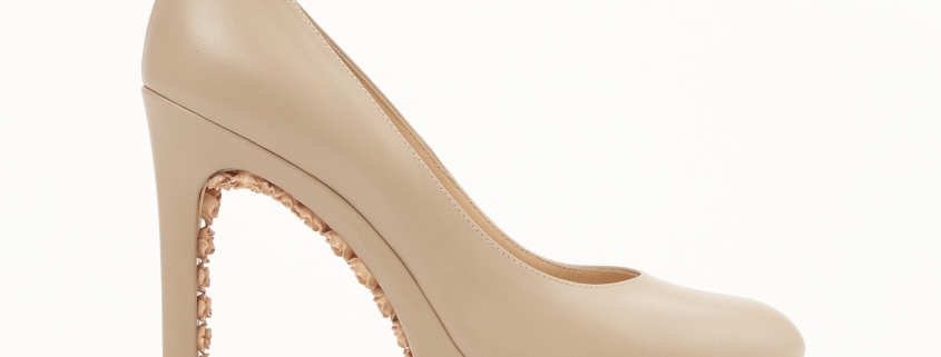 Beige high heel shoe with embellished heel.